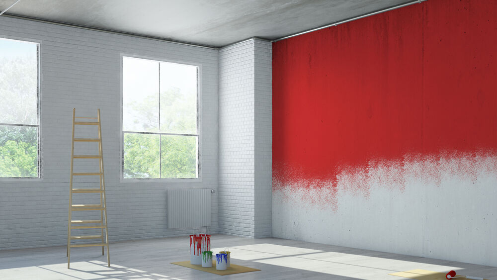 A room that is being decorated and a wall that is being painted with red paint.